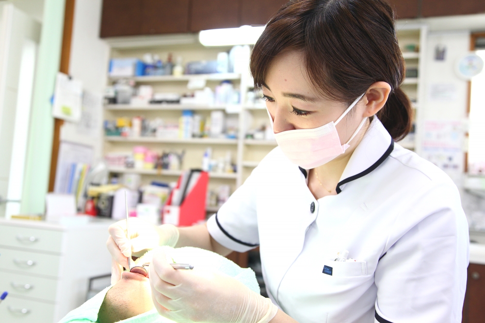 歯科衛生士が、歯石や歯垢を取り除いています